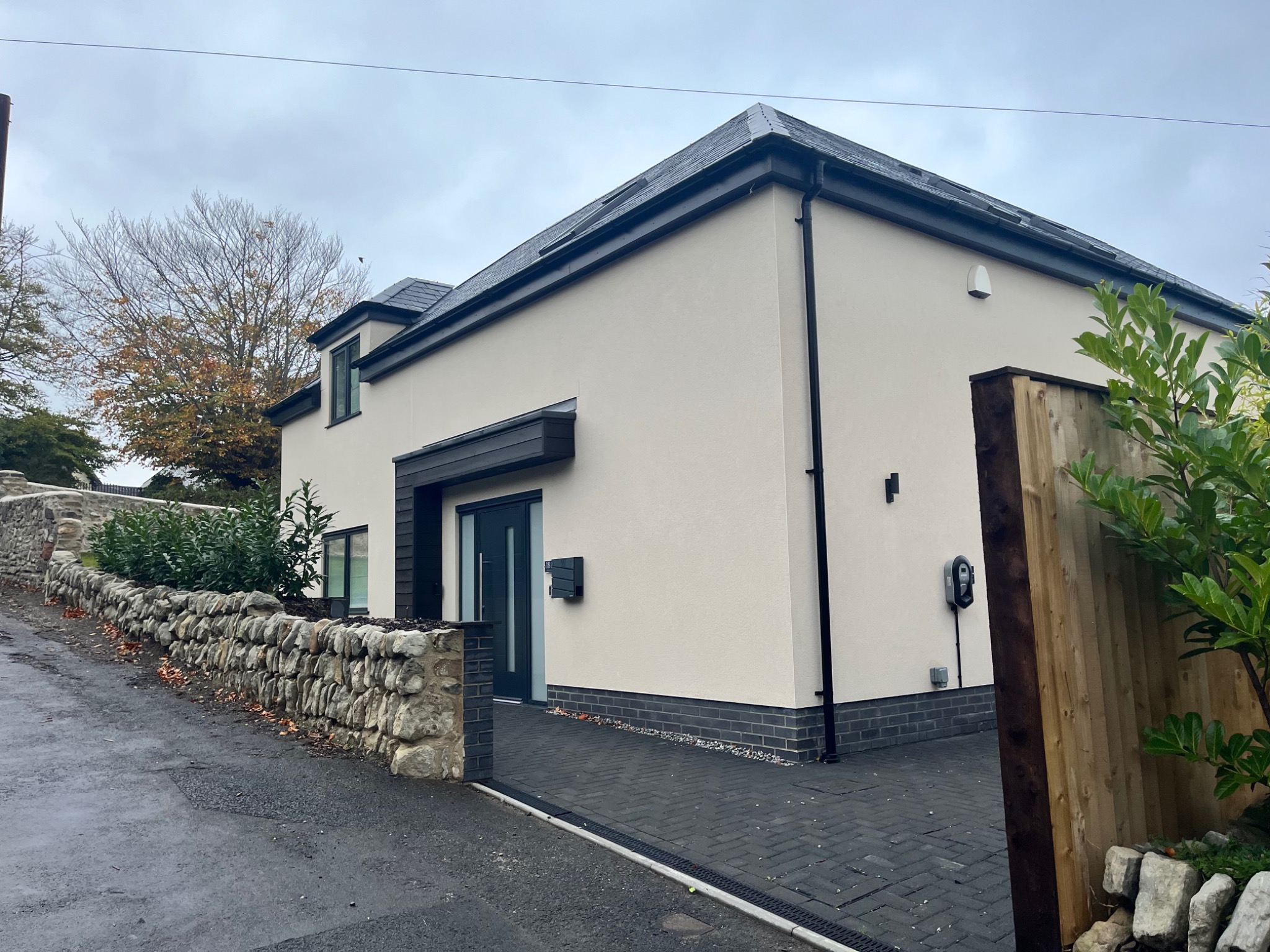 Rendered exterior with stone boundary wall